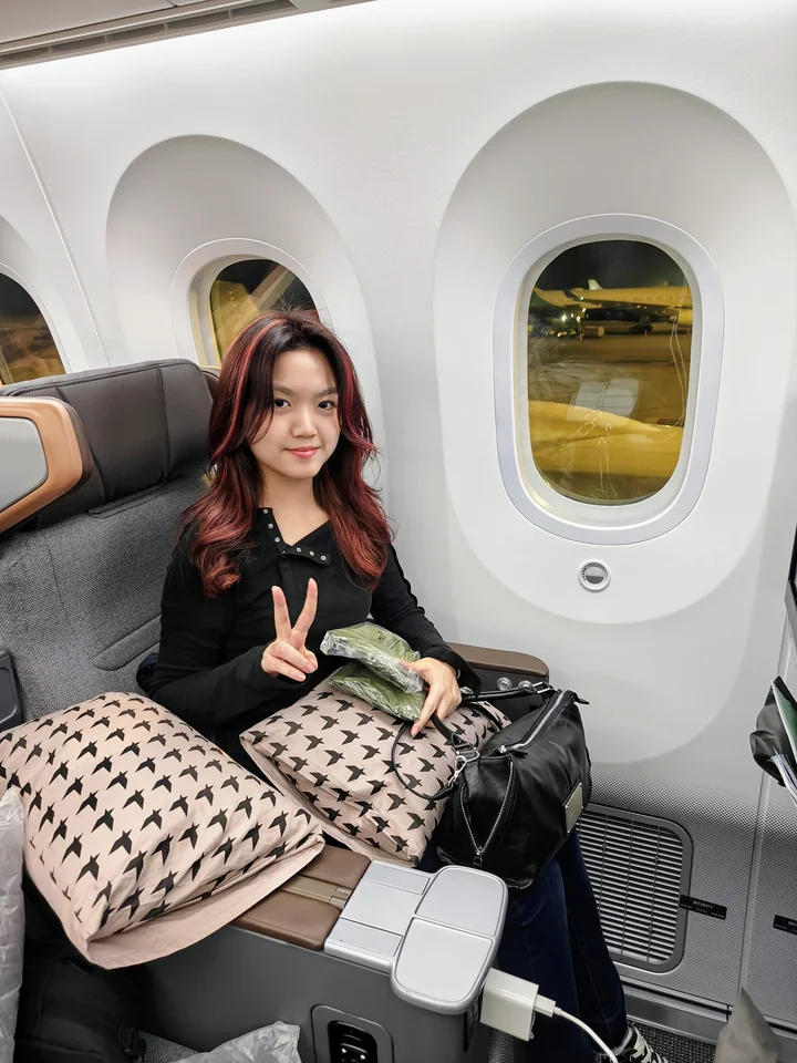 Belle 坐在長榮航空窗邊座位準備返台